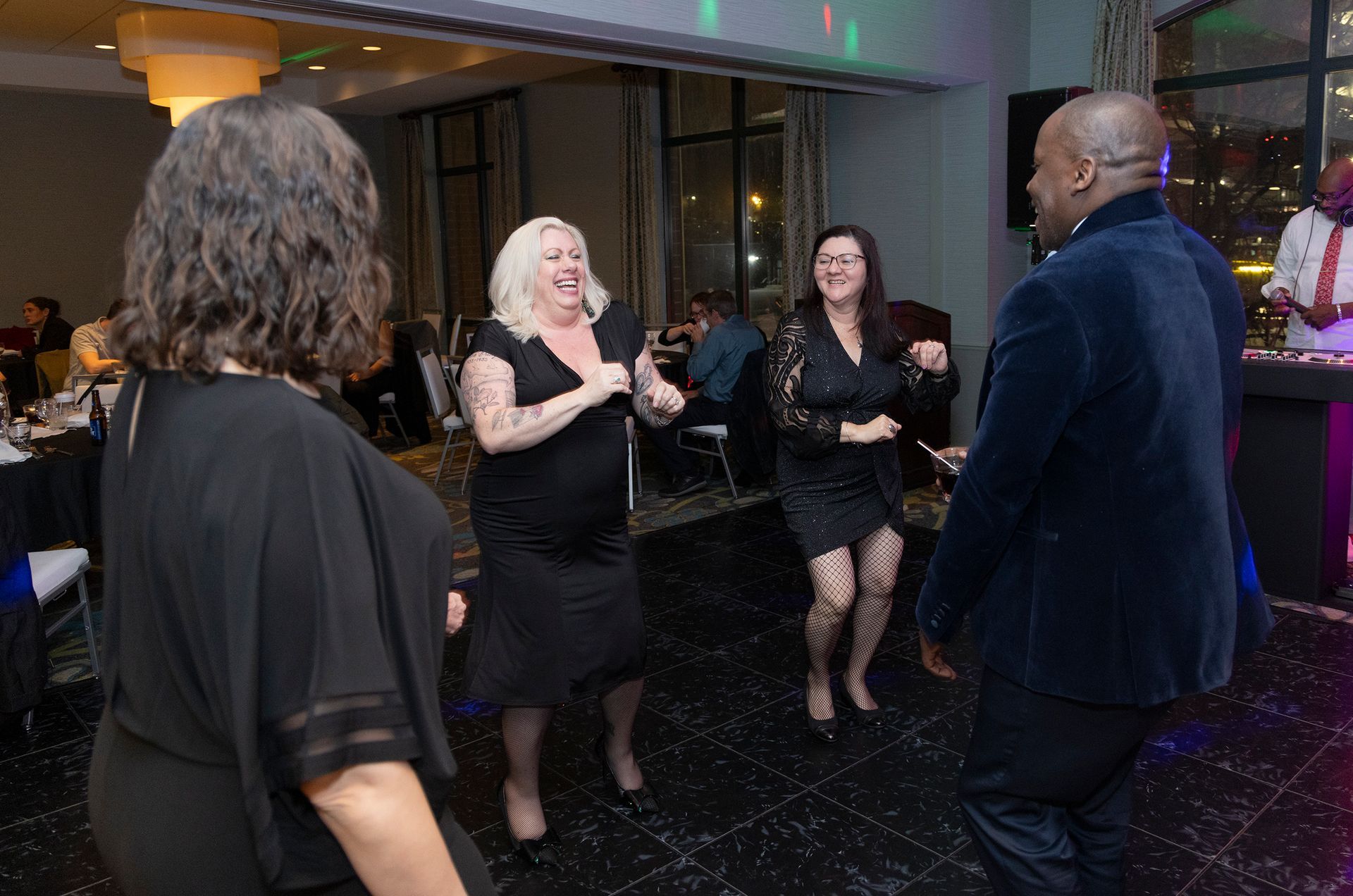A group of people are dancing in a room at a party.