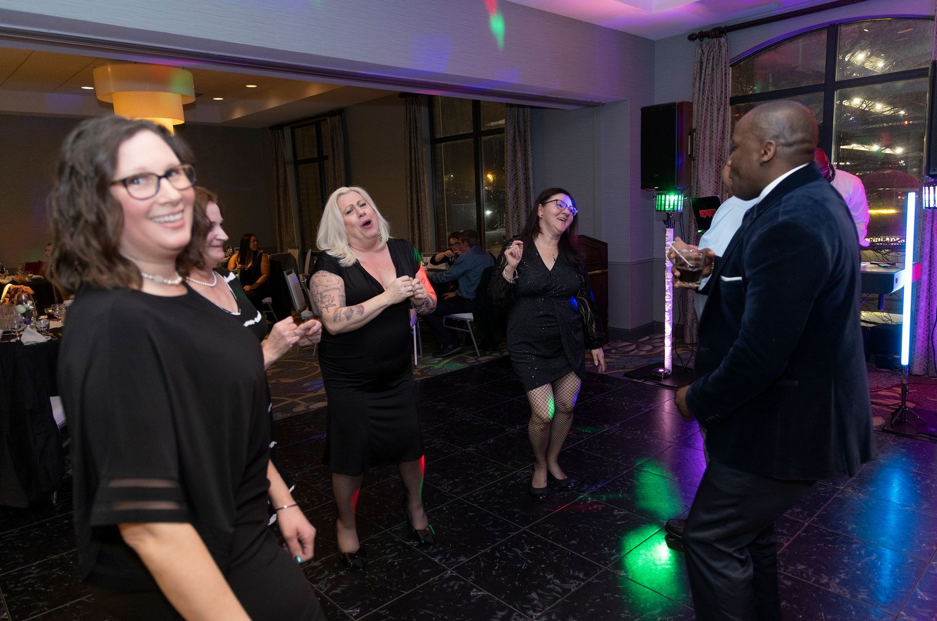 A group of people are dancing in a room at a party.