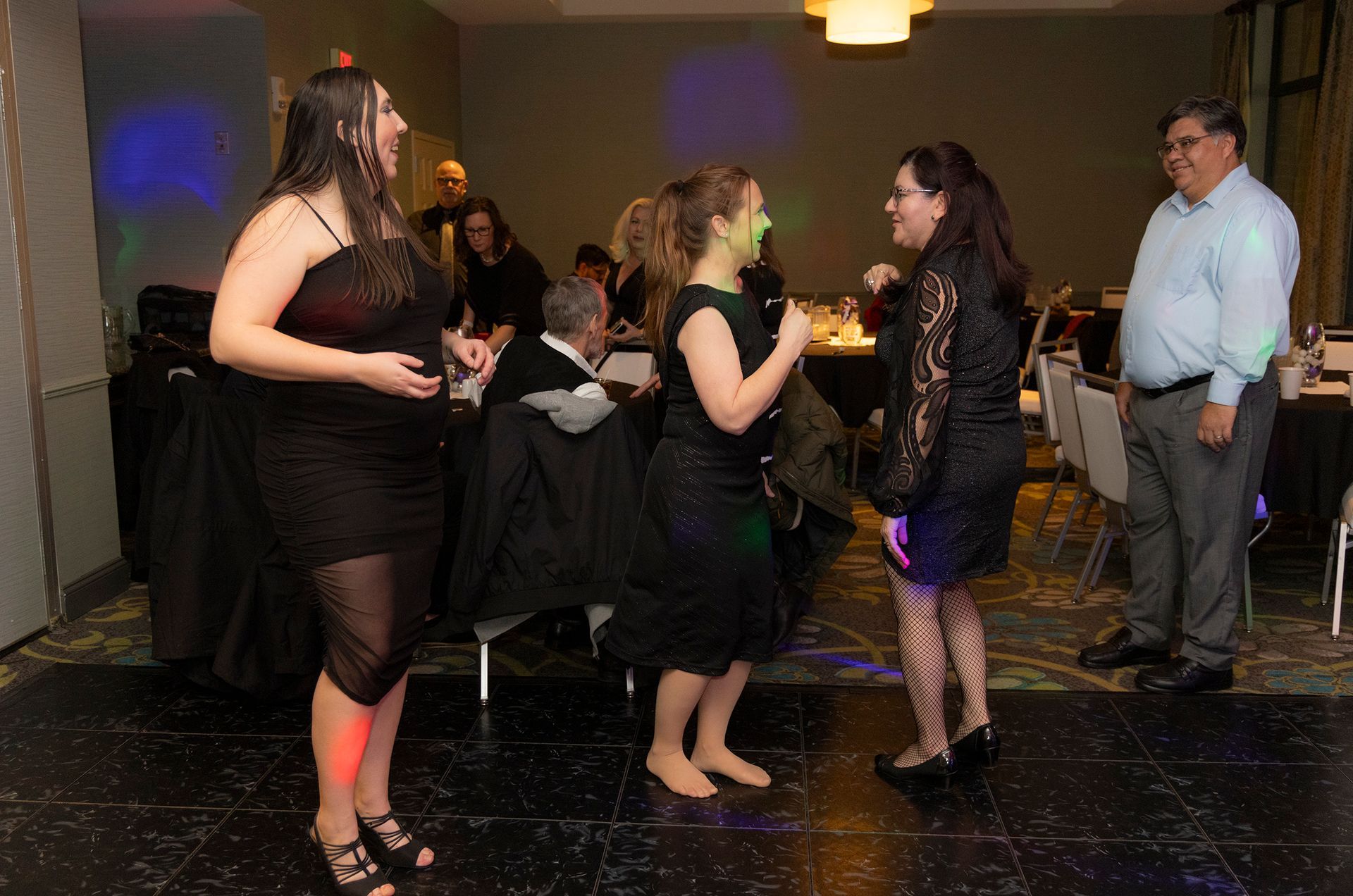 A group of women are dancing on a dance floor at a party.