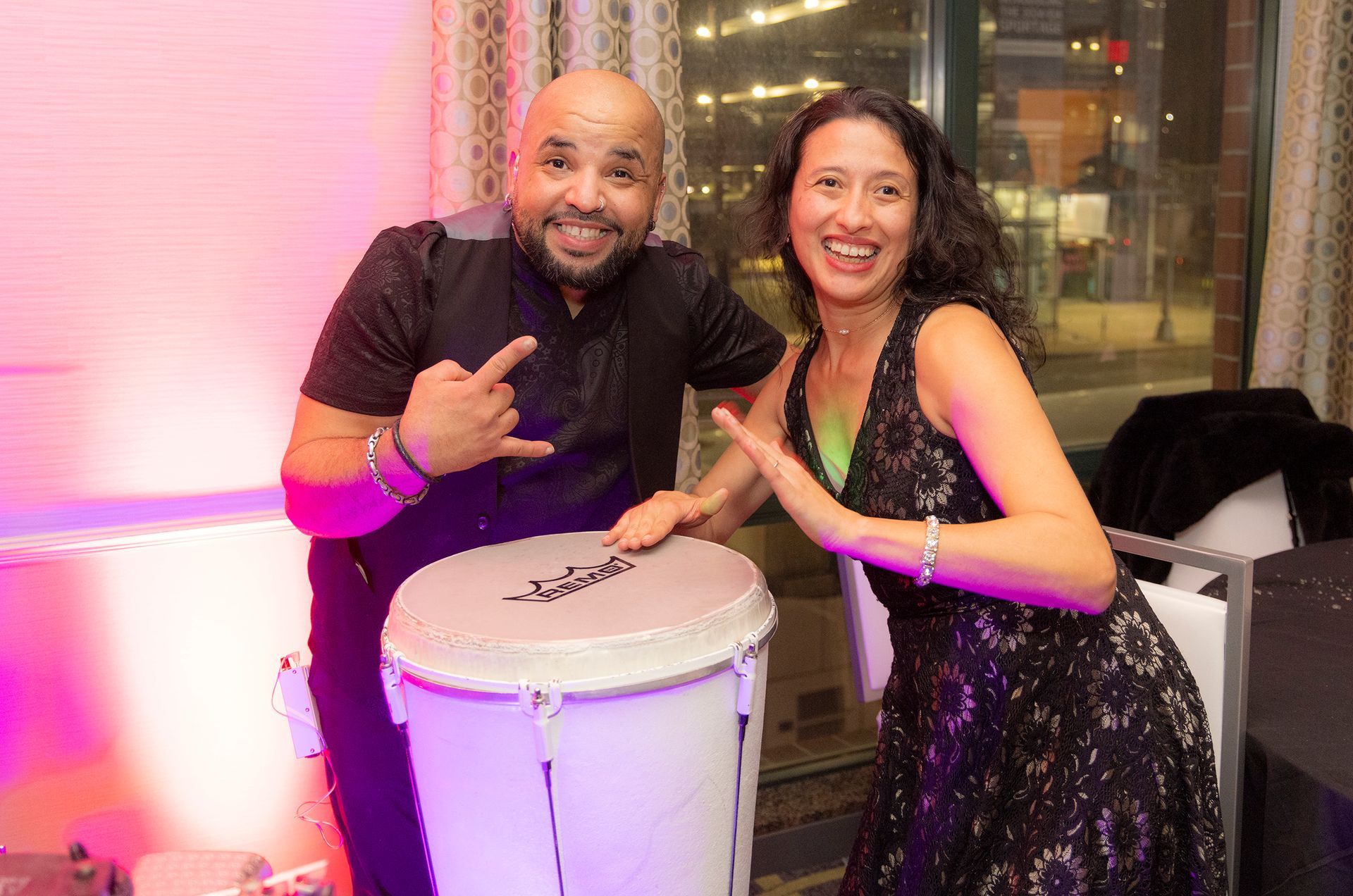 A man and a woman are standing next to a drum.