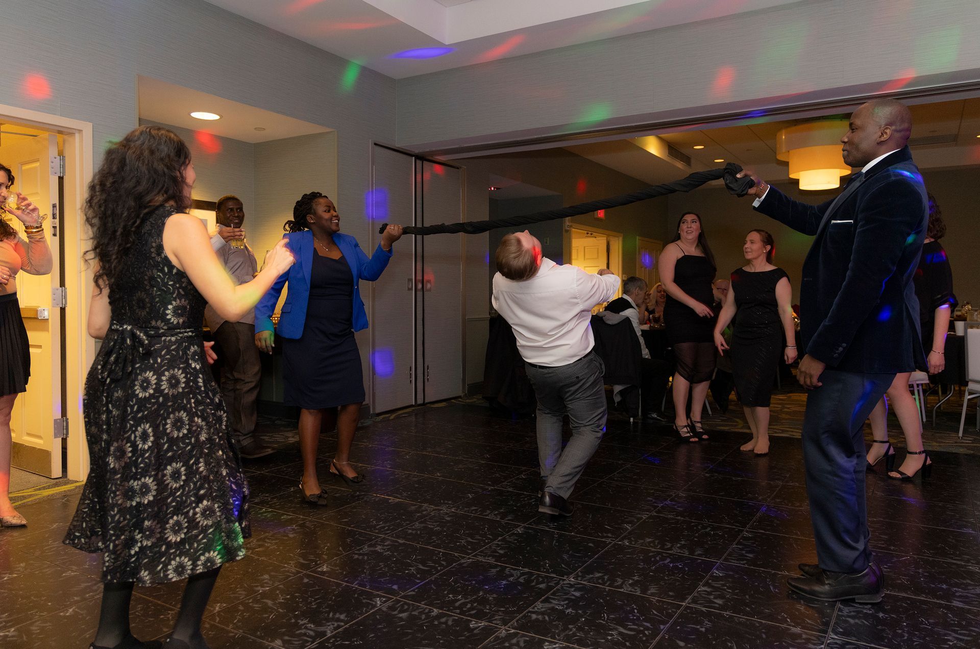 A group of people are dancing on a dance floor at a party.