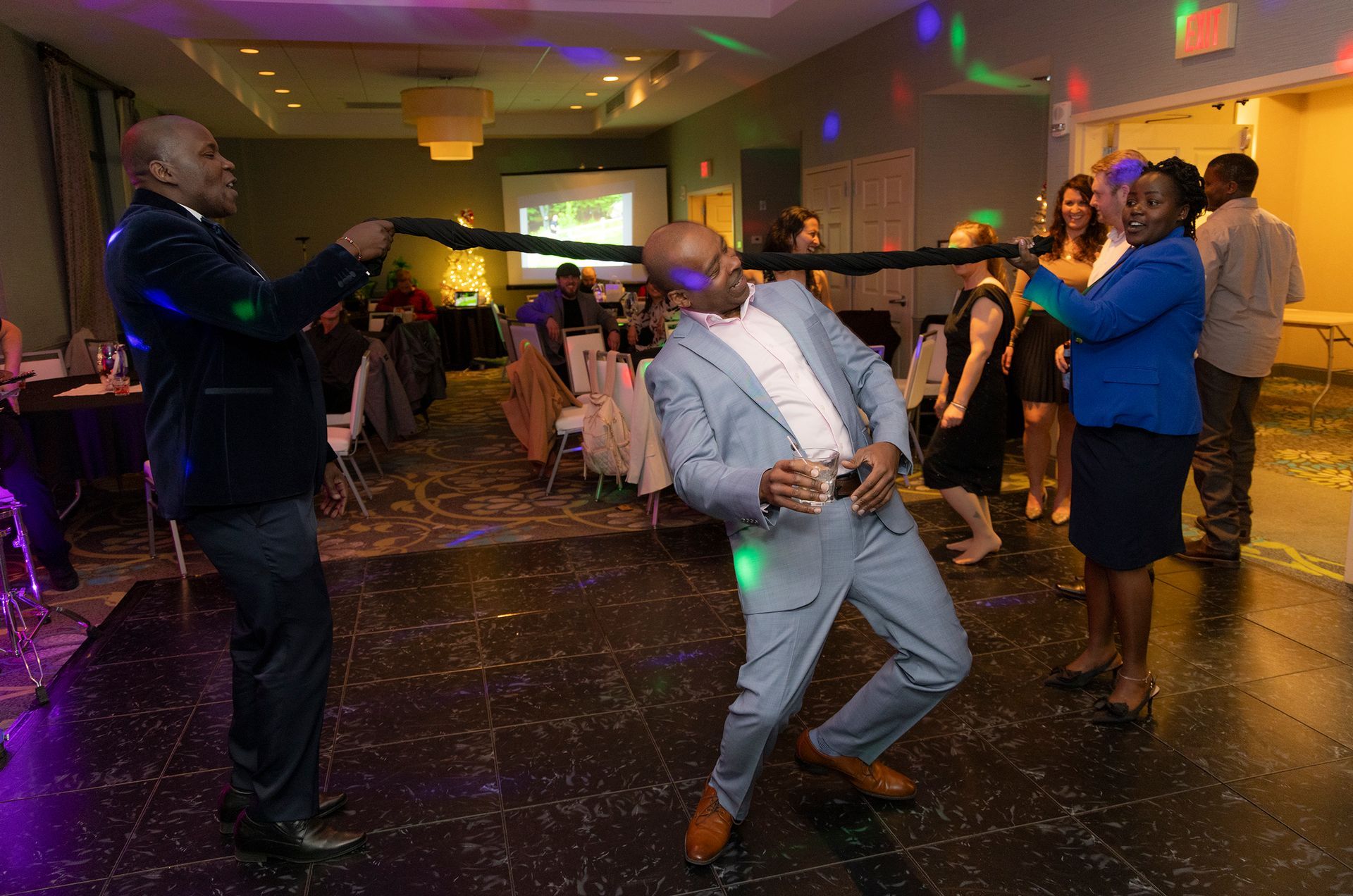 A group of people are dancing in a room at a party.