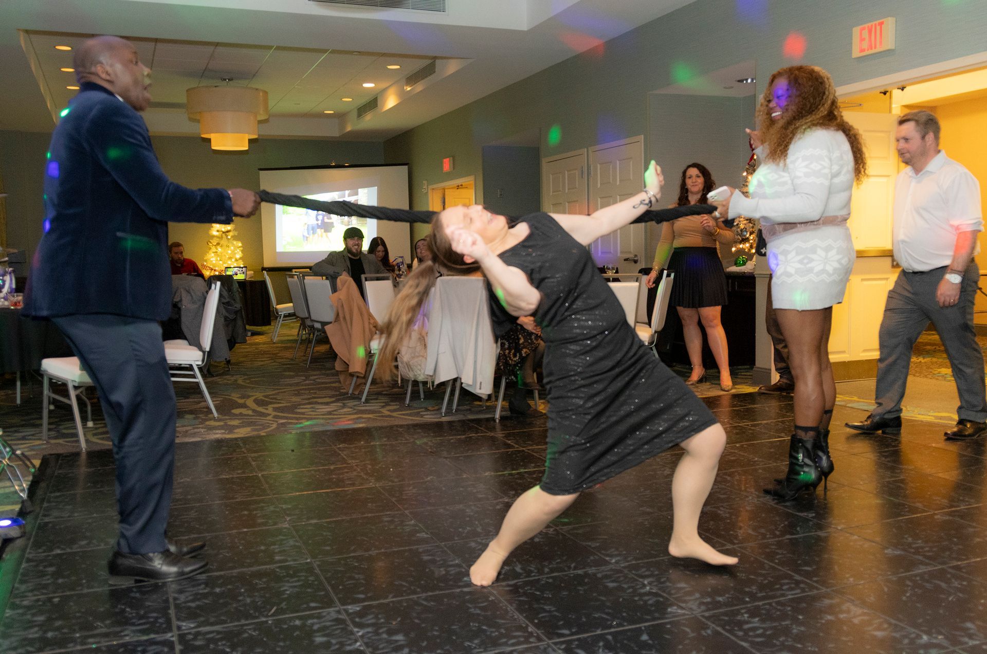 A group of people are dancing in a room at a party.