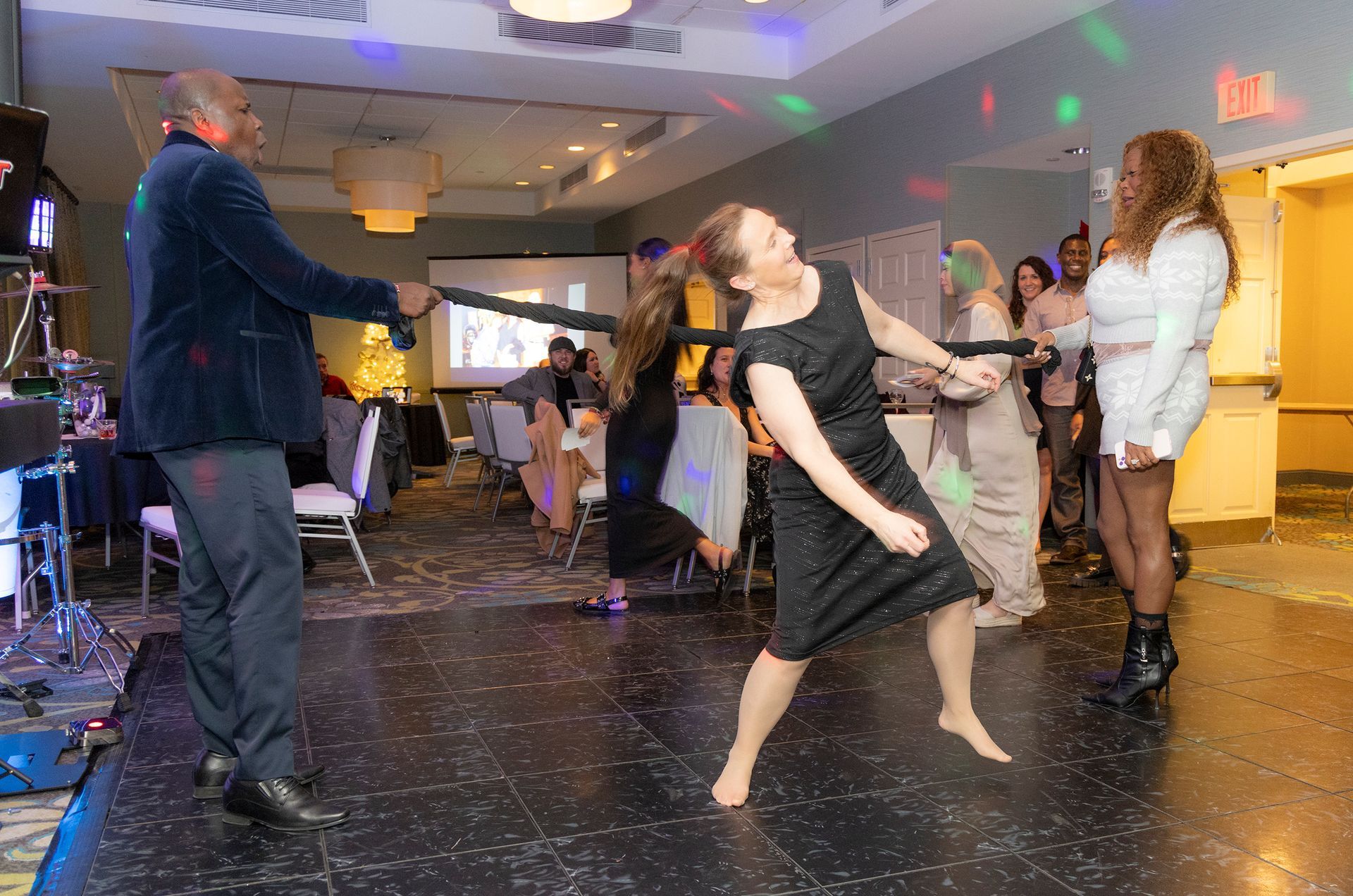 A group of people are dancing in a room at a party.