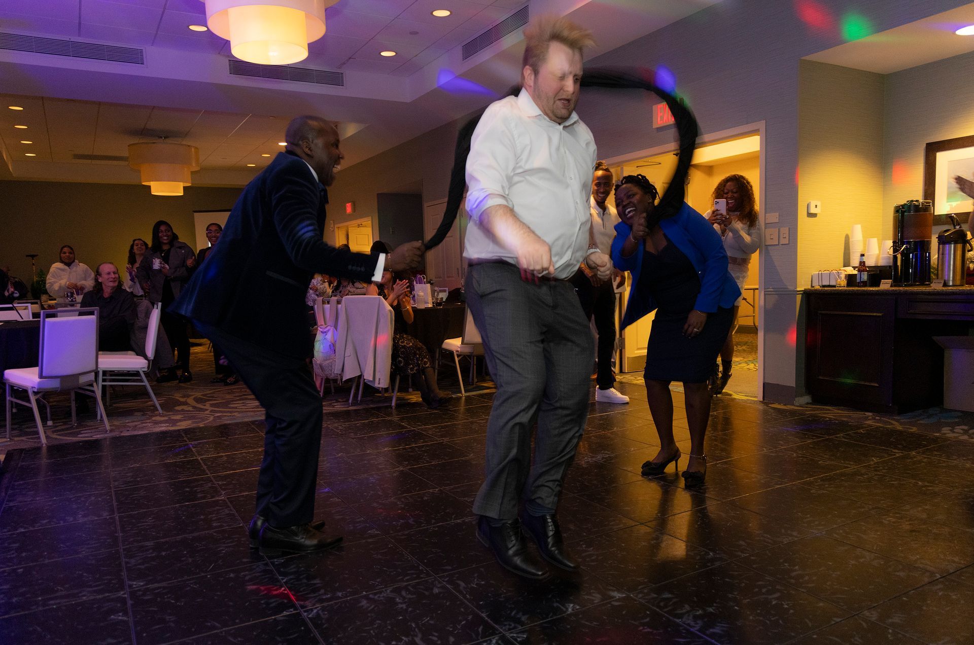 A group of people are dancing on a dance floor at a party.