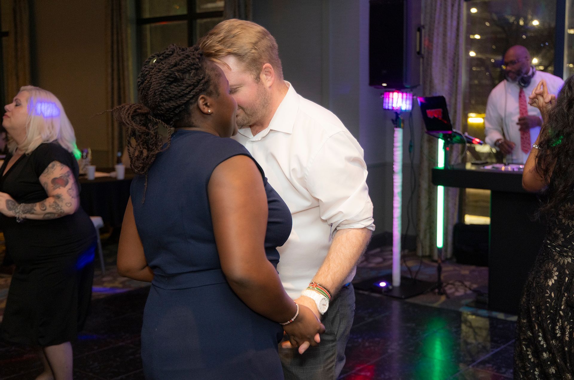 A man and a woman are dancing together at a party.