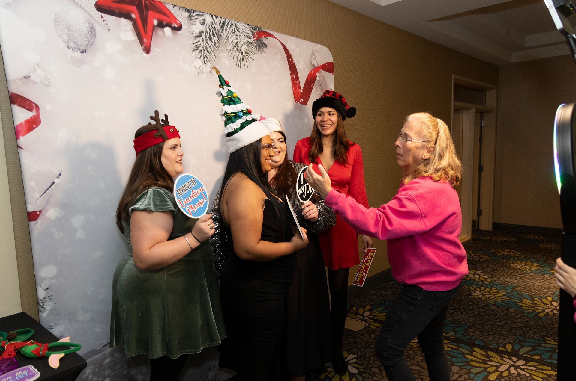 A group of women are posing for a picture in front of a photo booth.