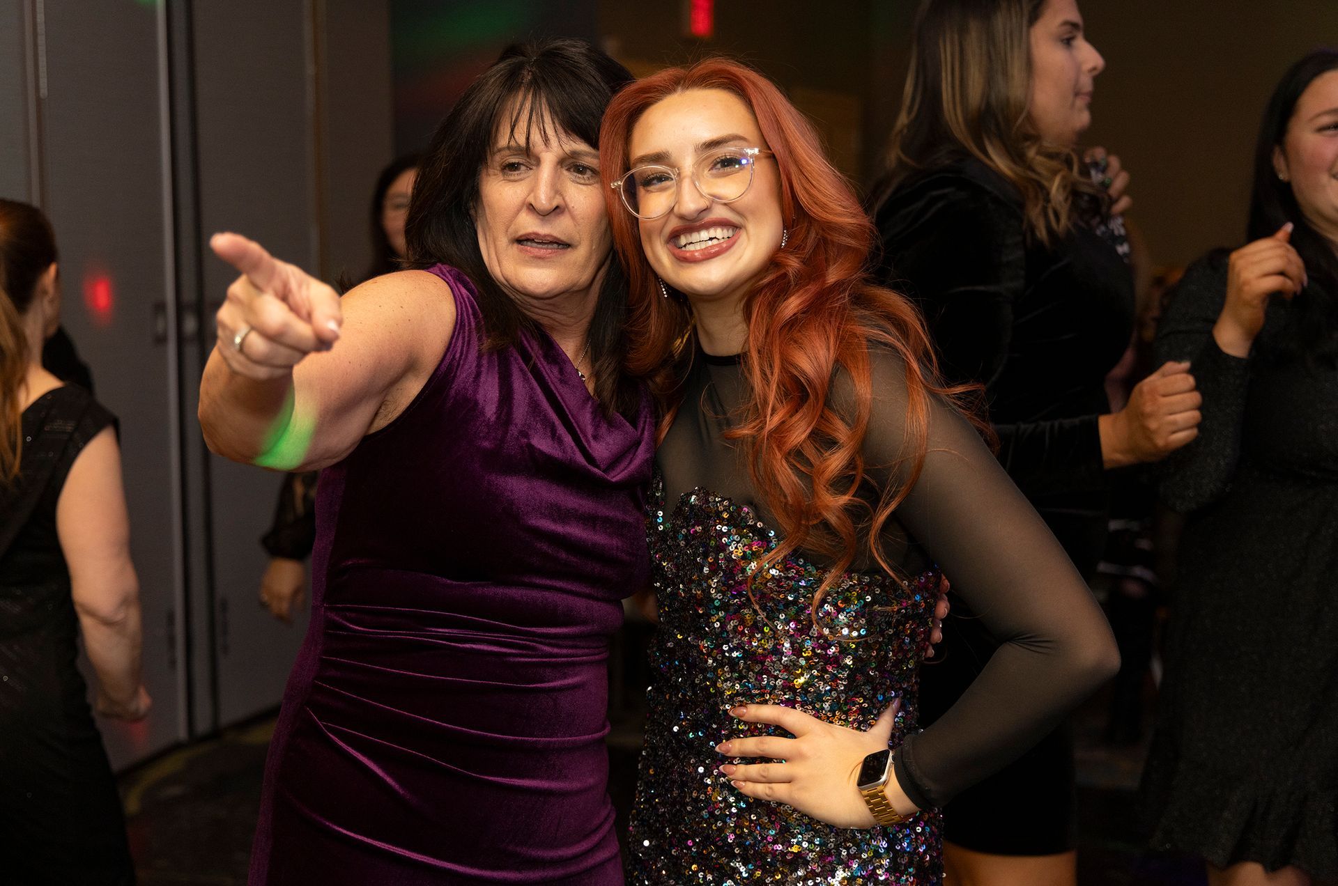 Two women are posing for a picture together at a party.