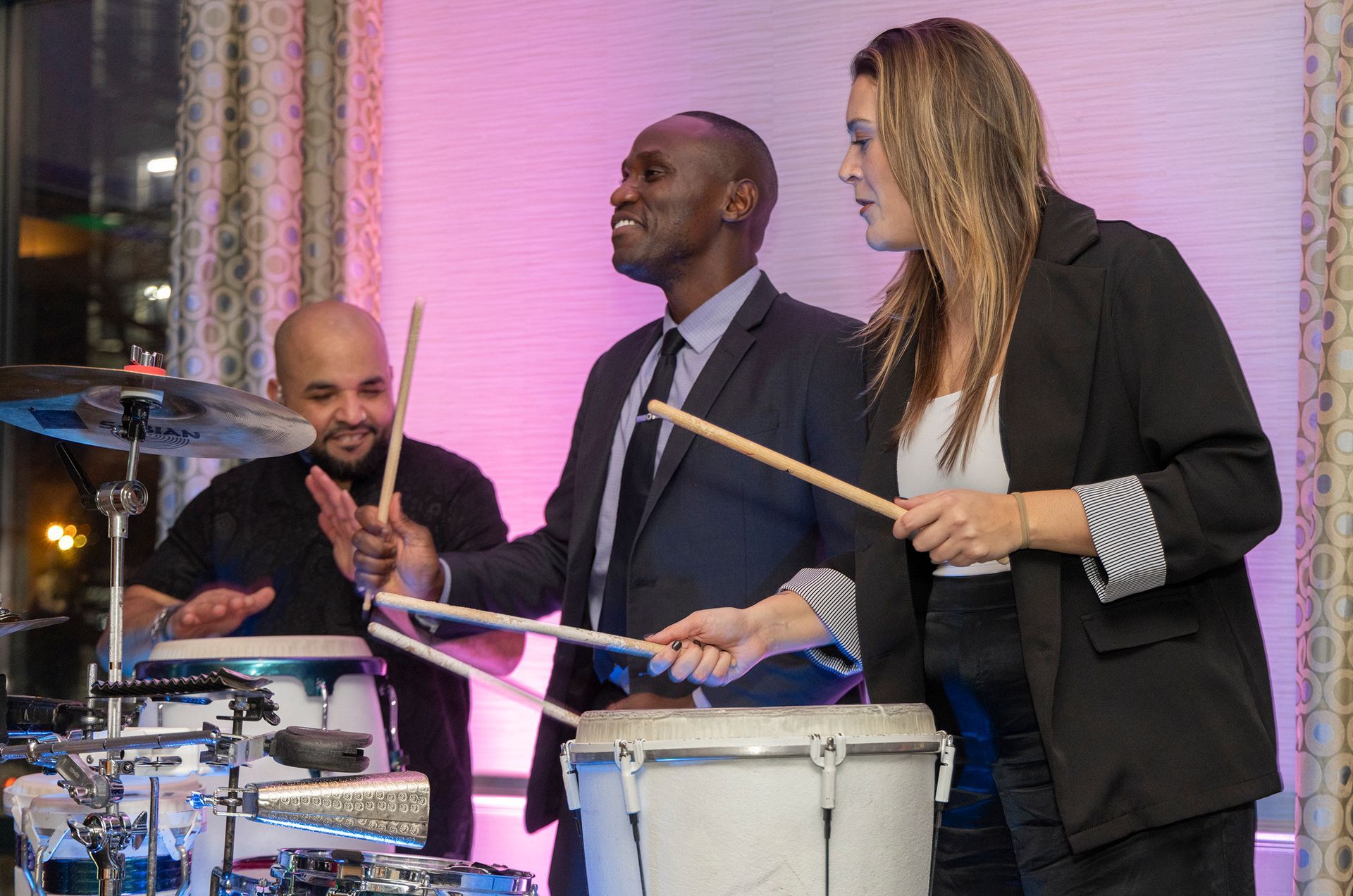 A man and a woman are playing drums in a band.