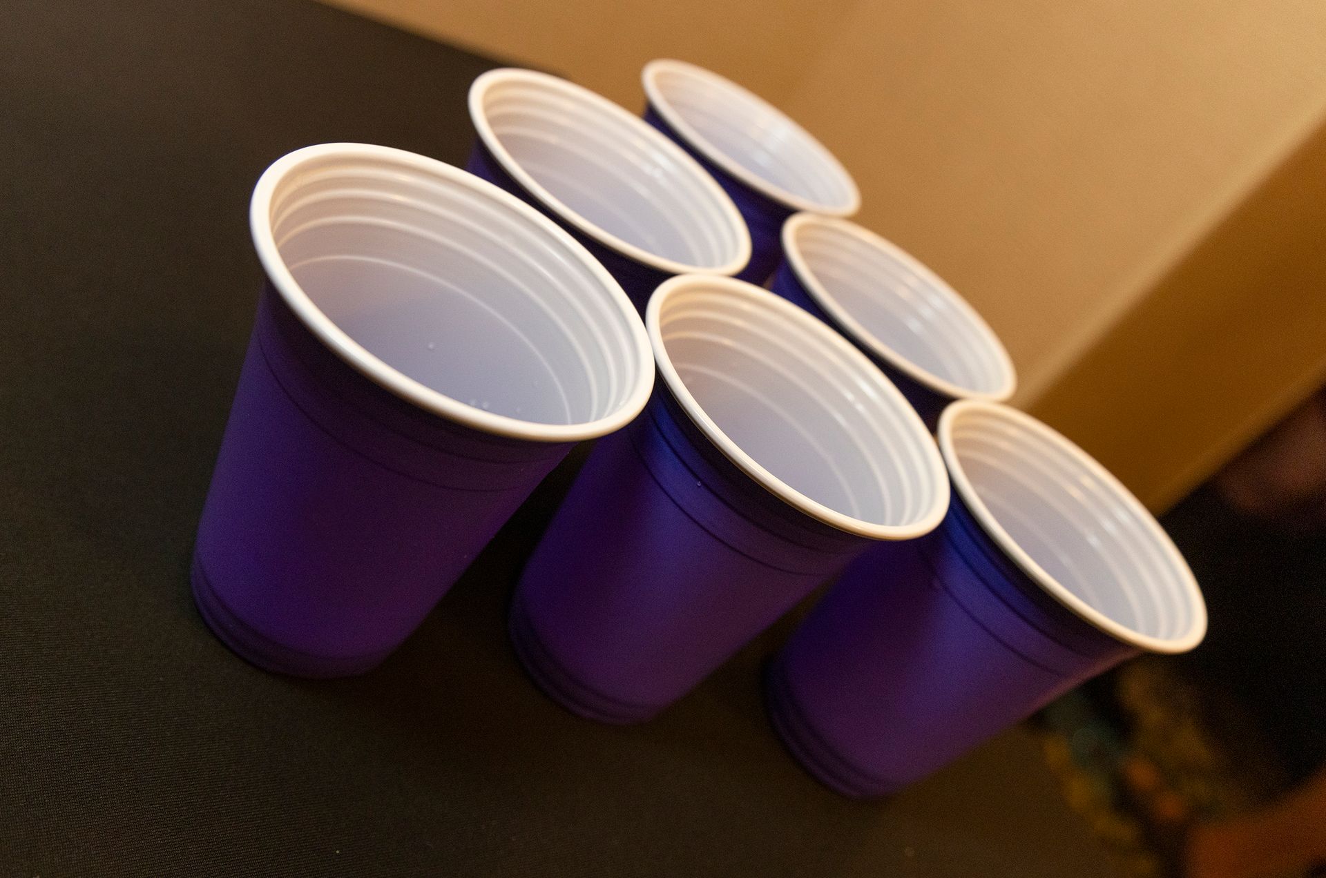 A bunch of purple cups are lined up on a table