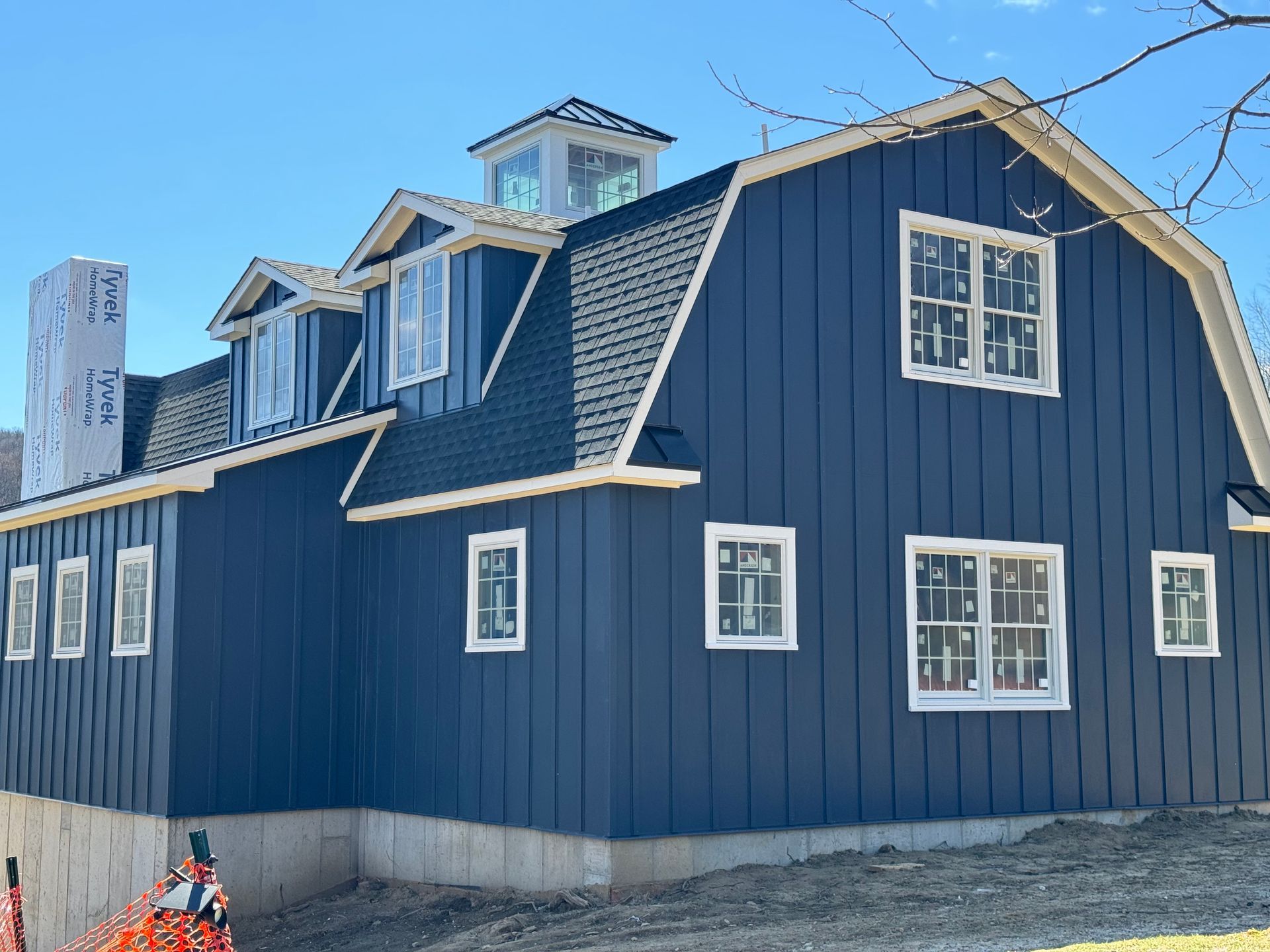 A large blue house with a barn roof and many windows