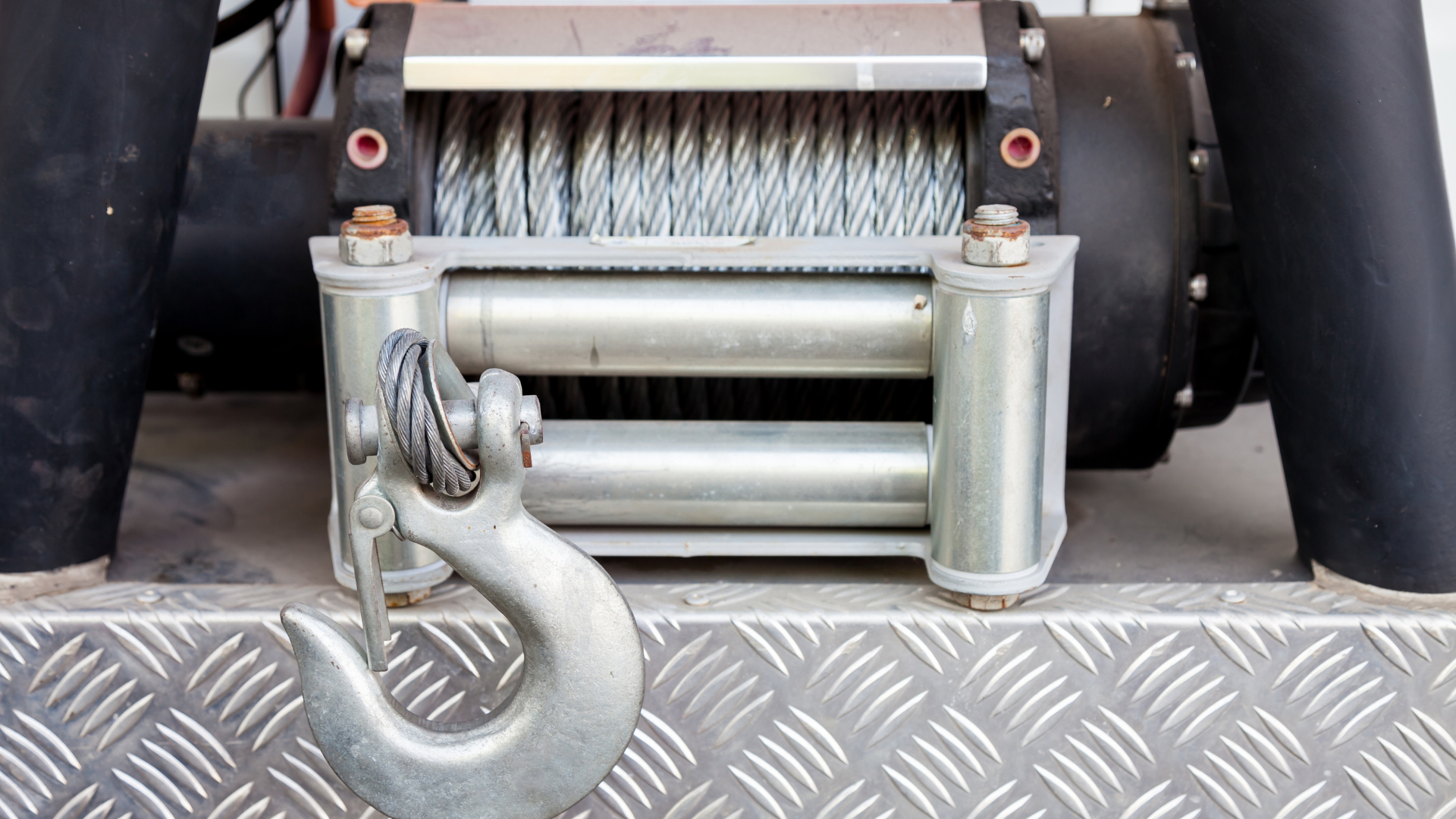 A close up of a winch with a hook attached to it.