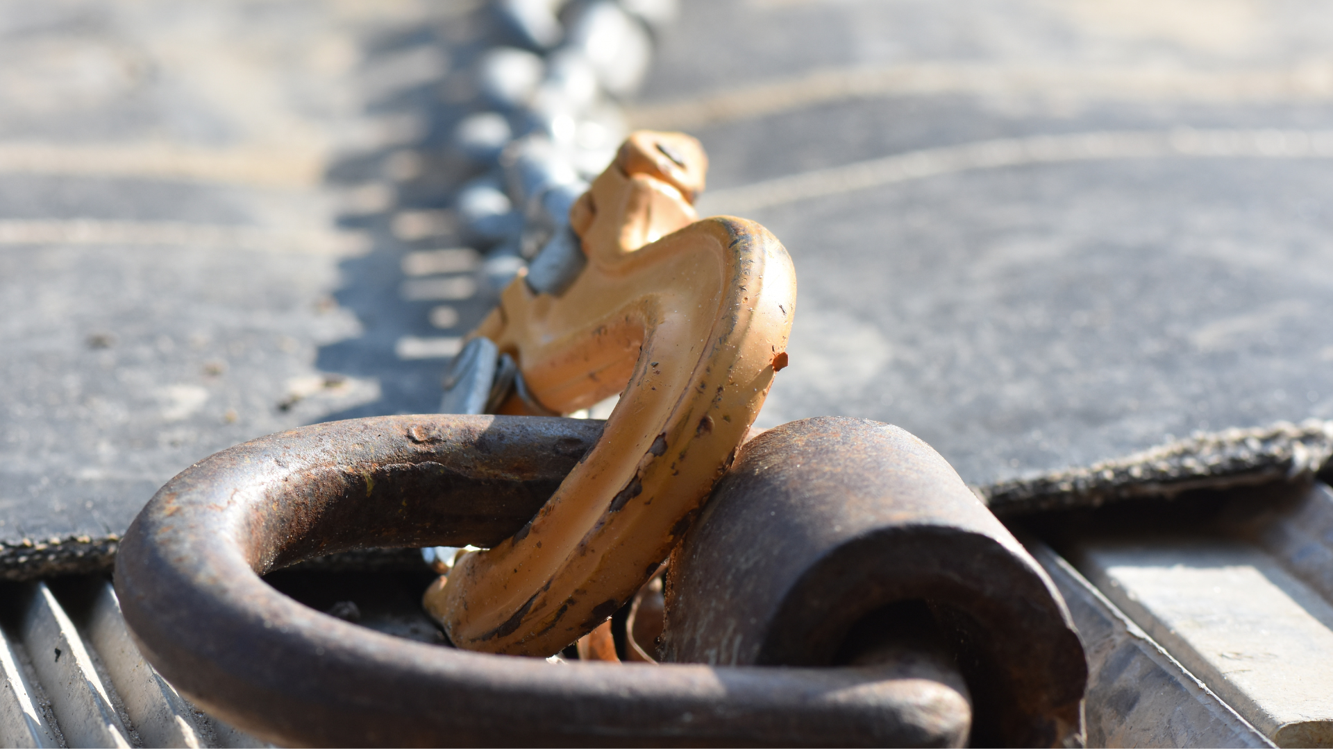 A close up of a rusty padlock on a chain.