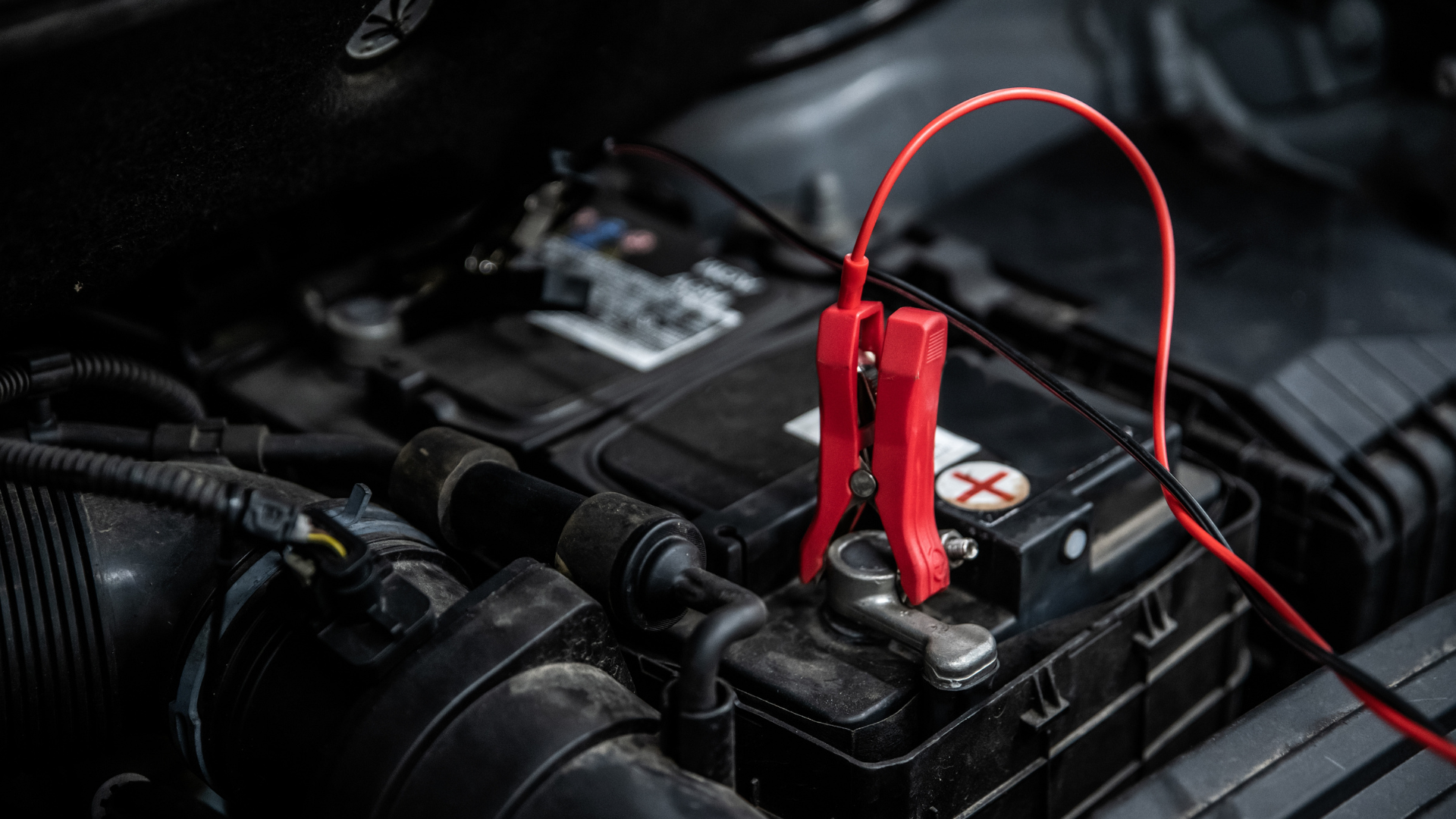 A car battery is being charged by a jump starter.