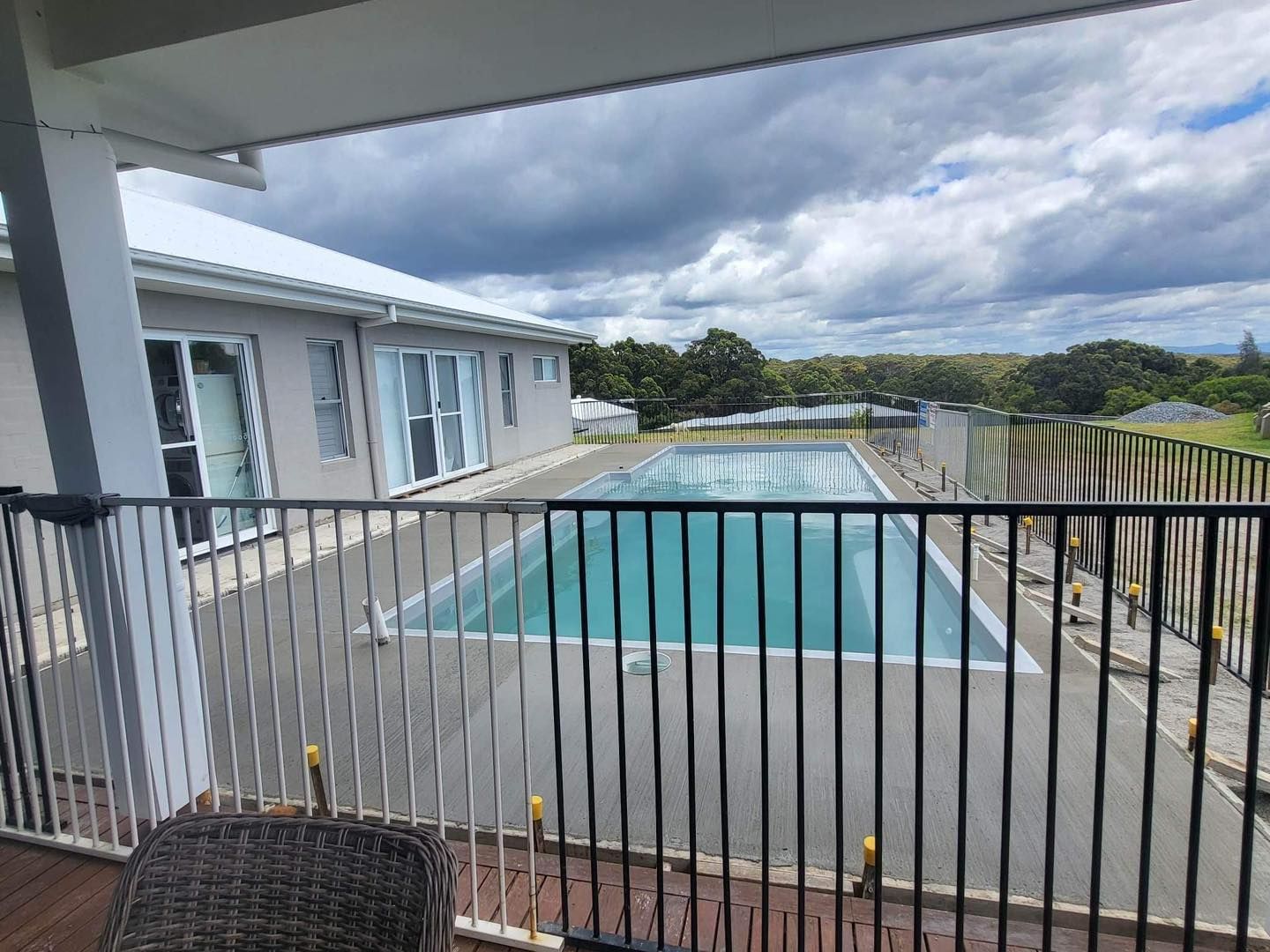 Pool Surrounded by Black Fence, Next to a Light-coloured House — Clearwater Pools Hallidays Point in Old Bar, NSW