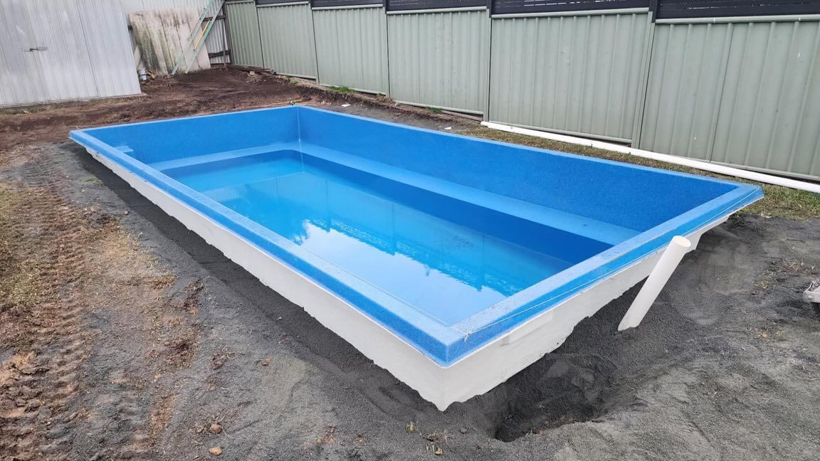 A Rectangular, Blue and White Swimming Pool Sits Partially Buried — Clearwater Pools Hallidays Point in Harrington, NSW