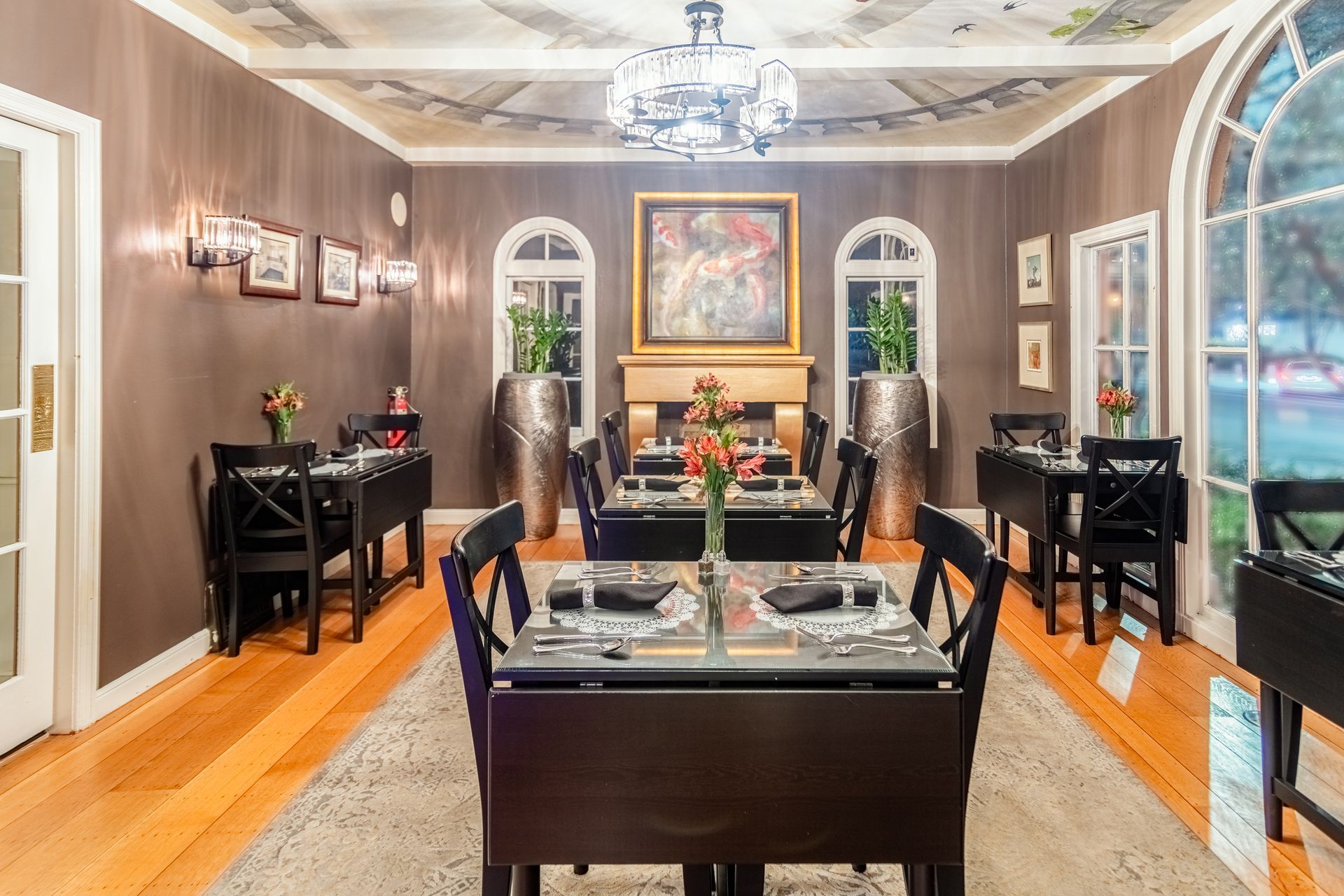 A large dining room with tables and chairs and a fireplace.