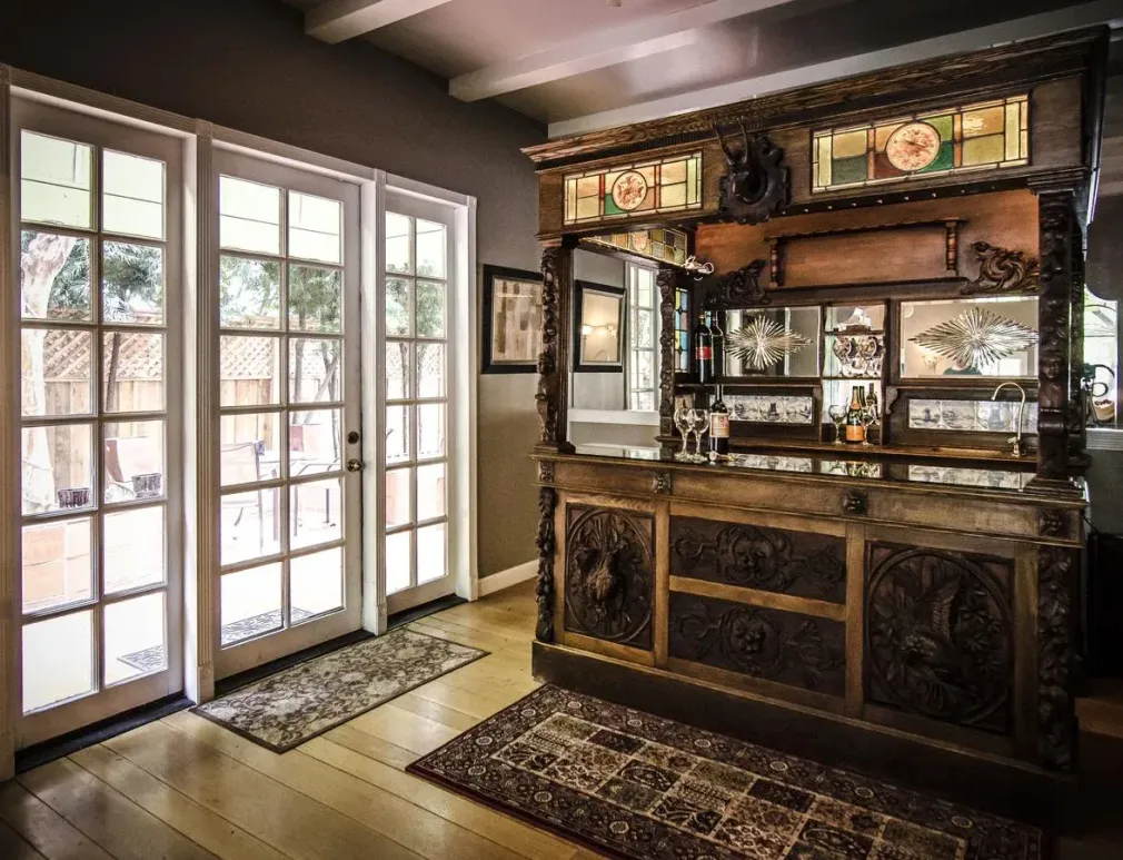 A large wooden bar in a living room with sliding glass doors.
