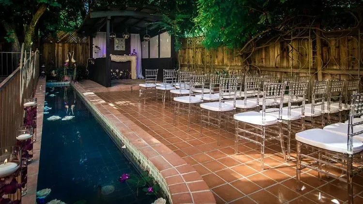 A row of chairs sitting next to a swimming pool.