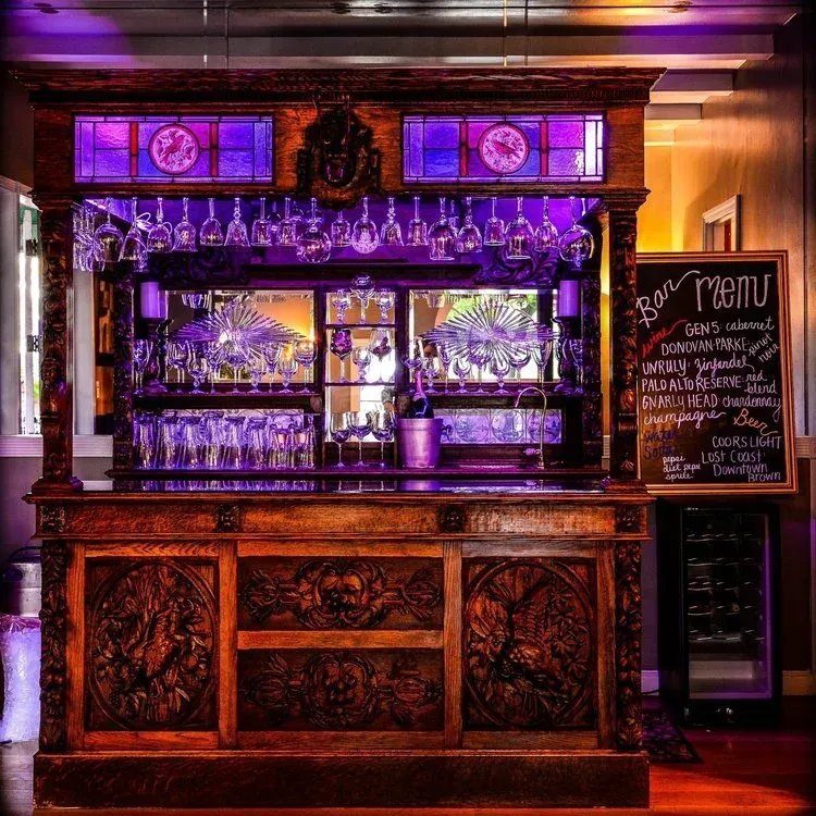 A bar with purple lights and a menu on it