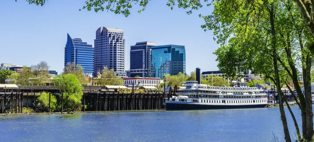 A boat is docked in front of a city skyline.