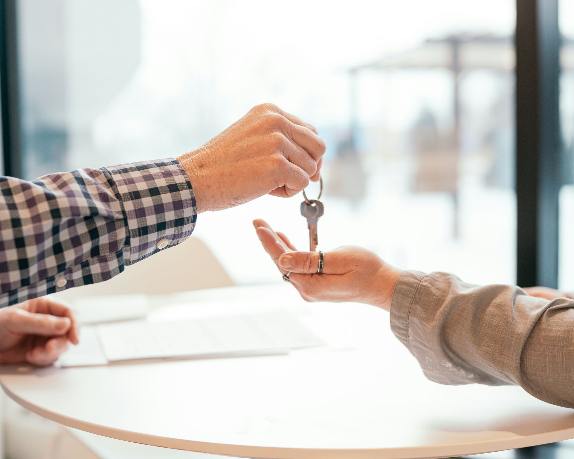 A man is handing a key to a woman at a table.
