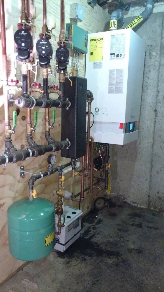 Heating system components: boiler, tank, pipes, and valves in a basement.