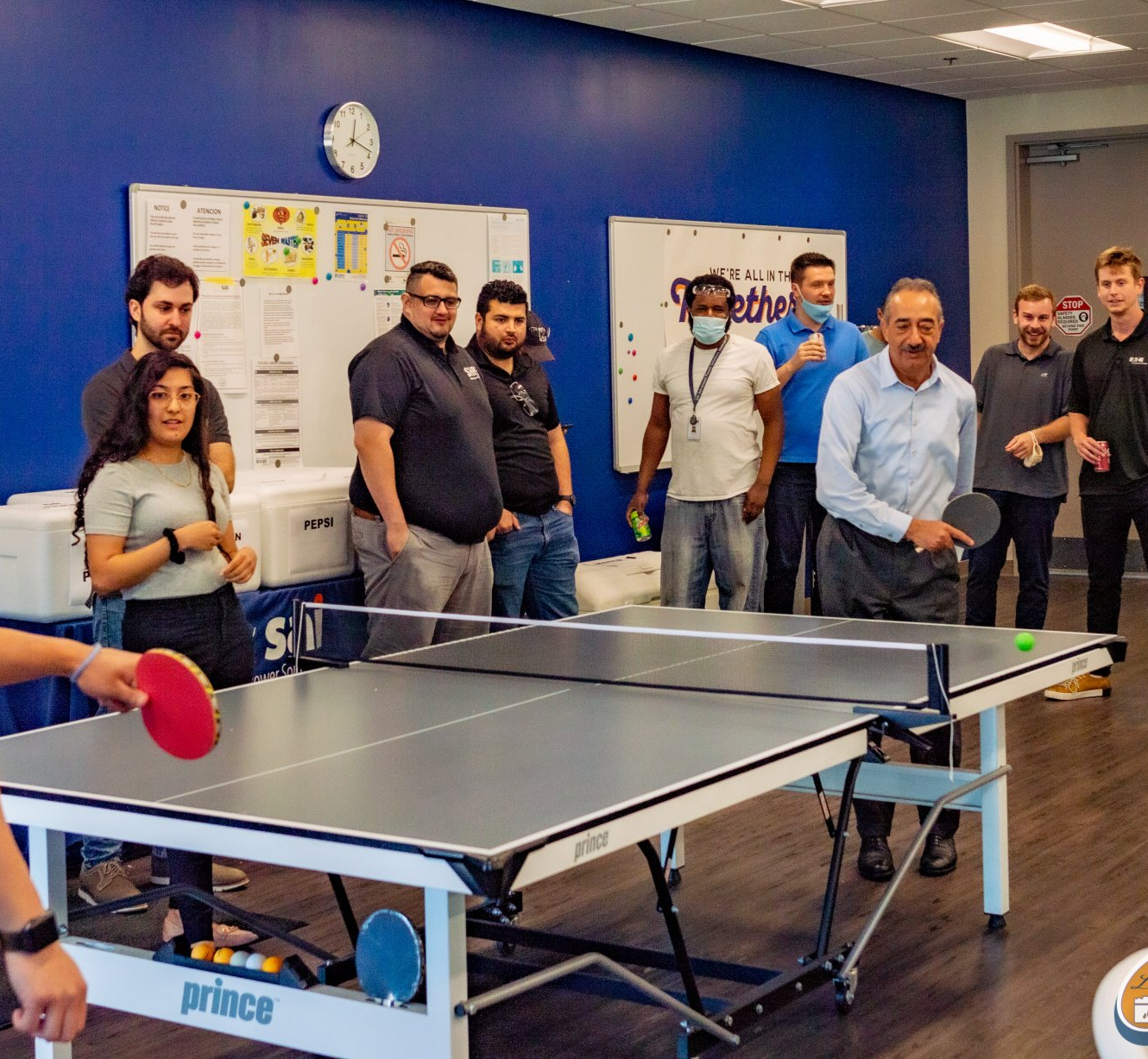 A group of people are playing ping pong on a prince table