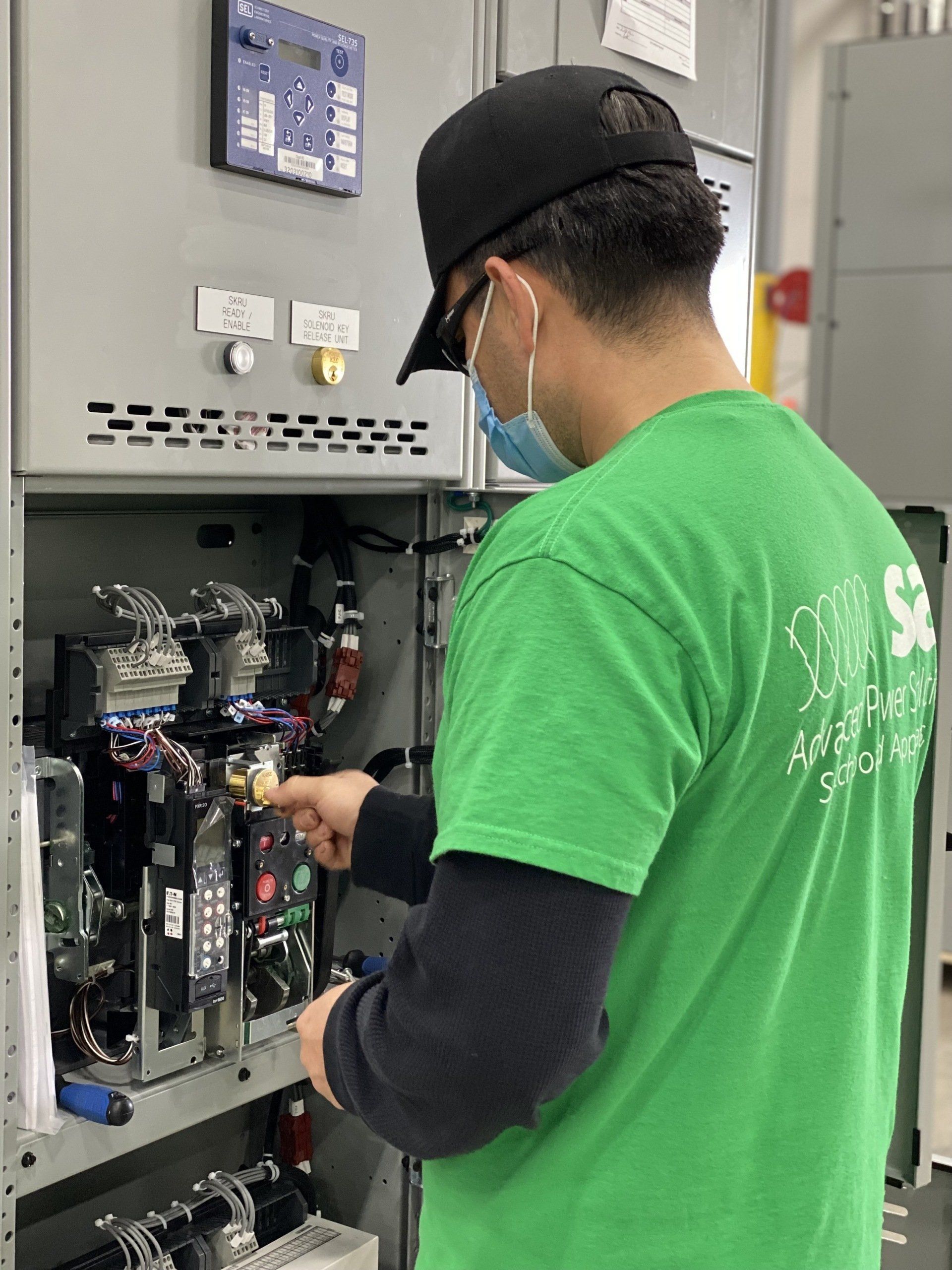 A man in a green shirt is working on a machine.