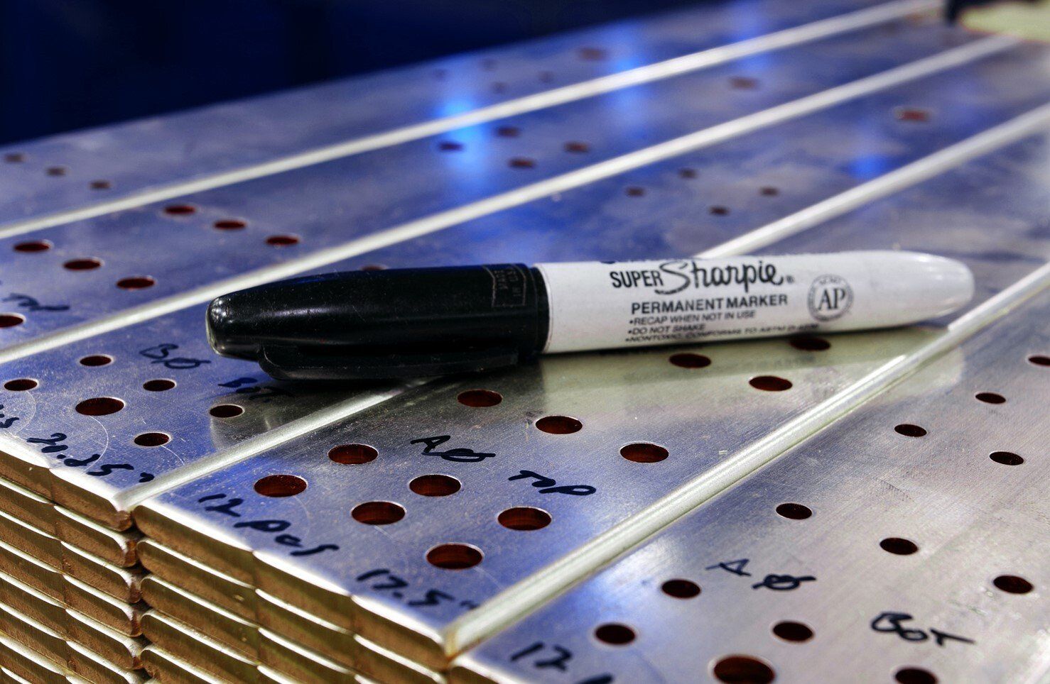 A sharpie marker is sitting on top of a stack of metal plates