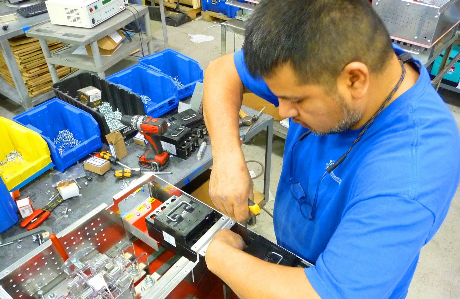 A man in a blue shirt is working on a piece of equipment