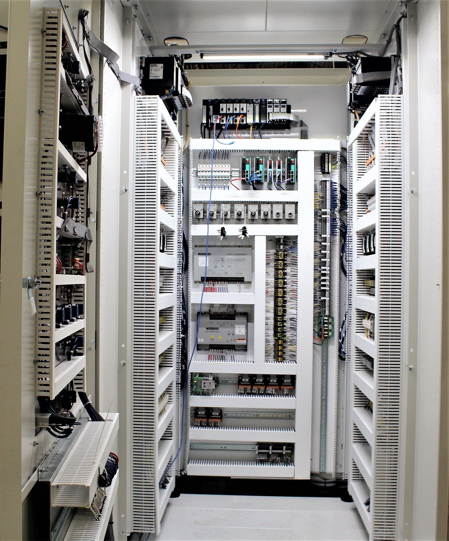 A room with a lot of shelves and electrical panels