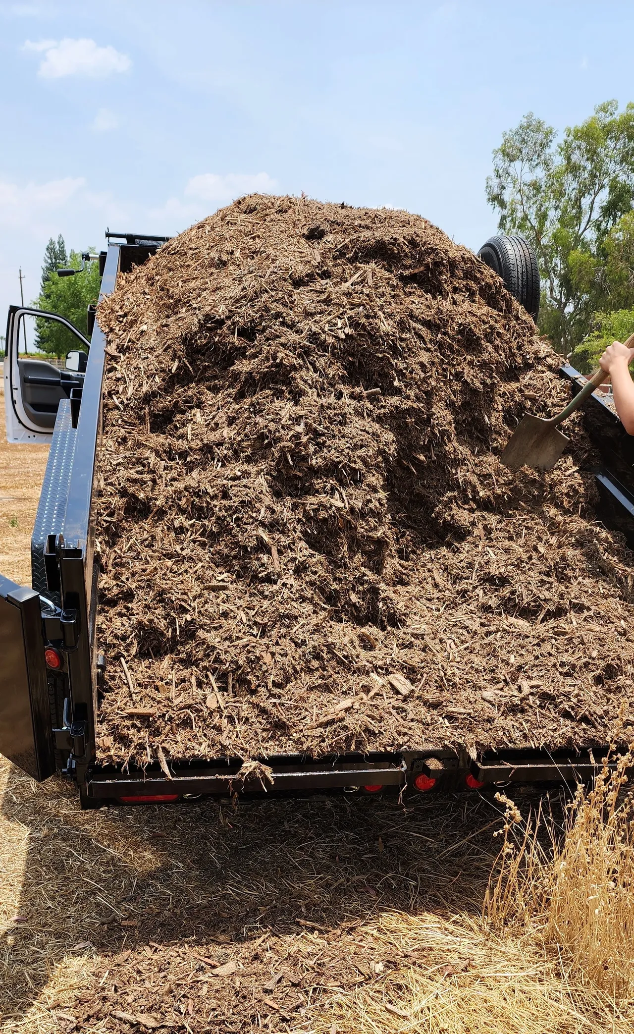 A large pile of mulch is being delivered in Bakersfield