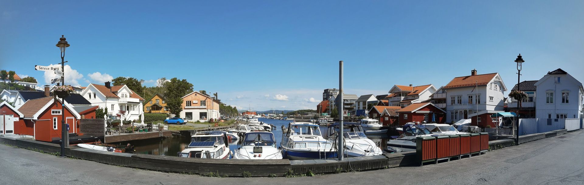 Havn med båter, bygninger og en klar blå himmel i en kystby.