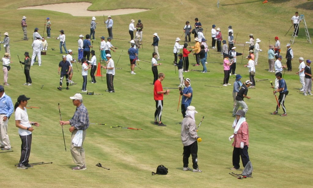 A large group of people are standing on a golf course