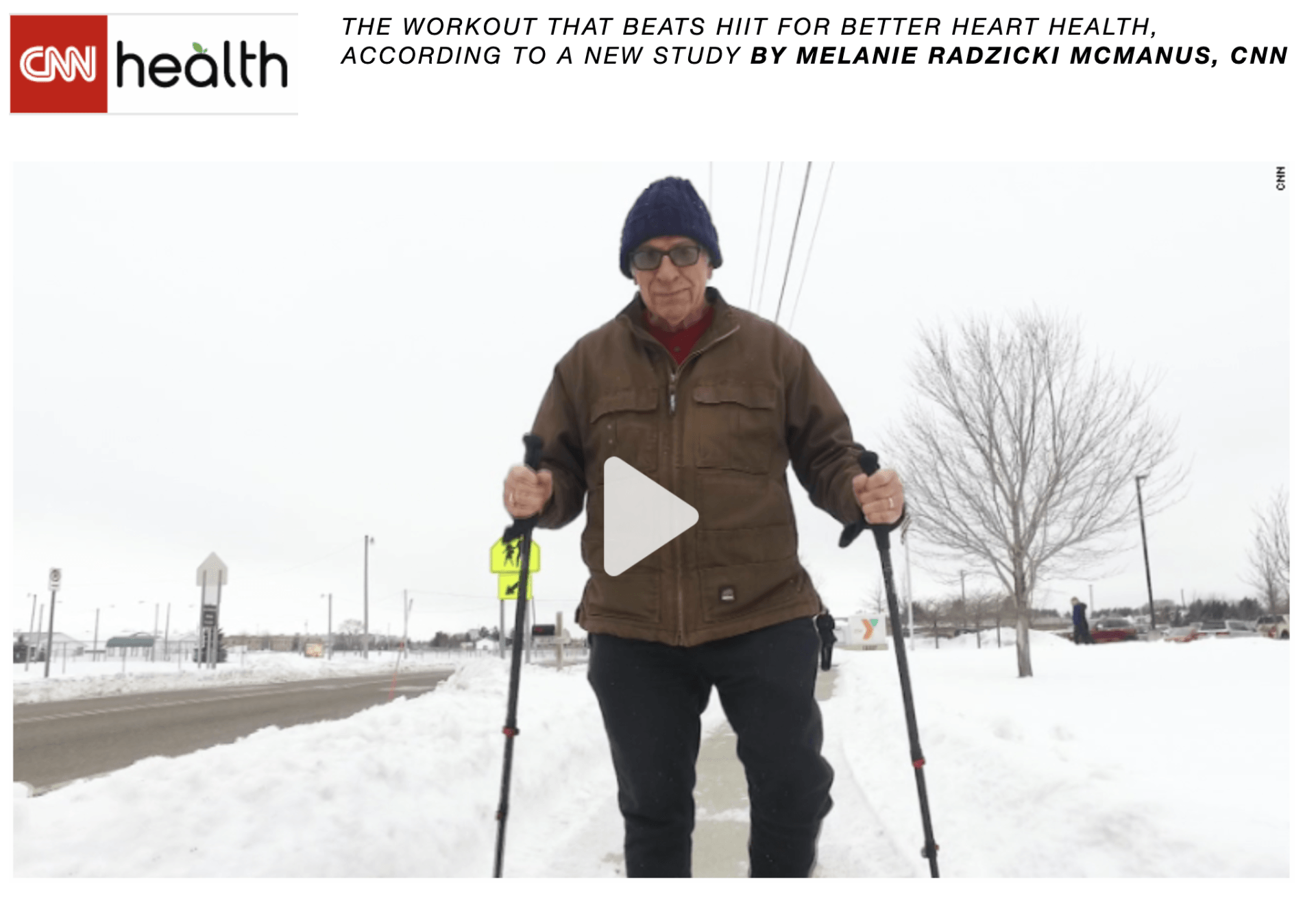 A man is walking in the snow with walking poles.