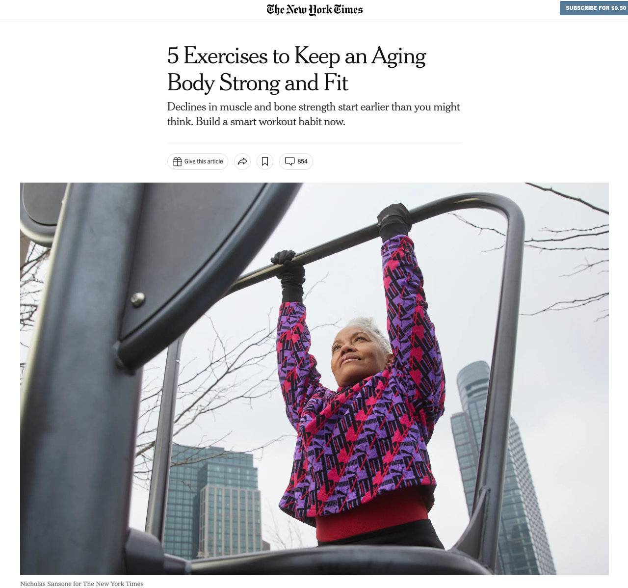 A woman is doing pull ups on a bar in a park.