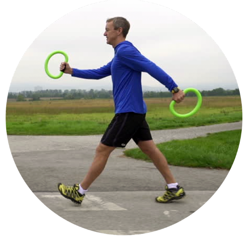 A man in a blue shirt is walking with two green rings in his hands