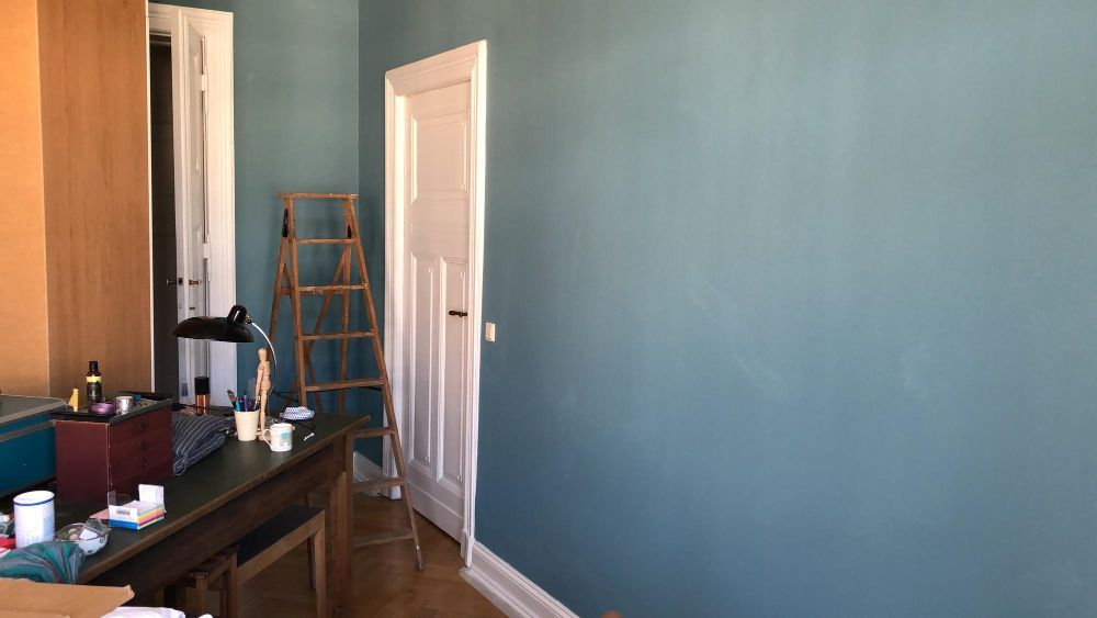 A room with blue walls and a table and chairs in it.