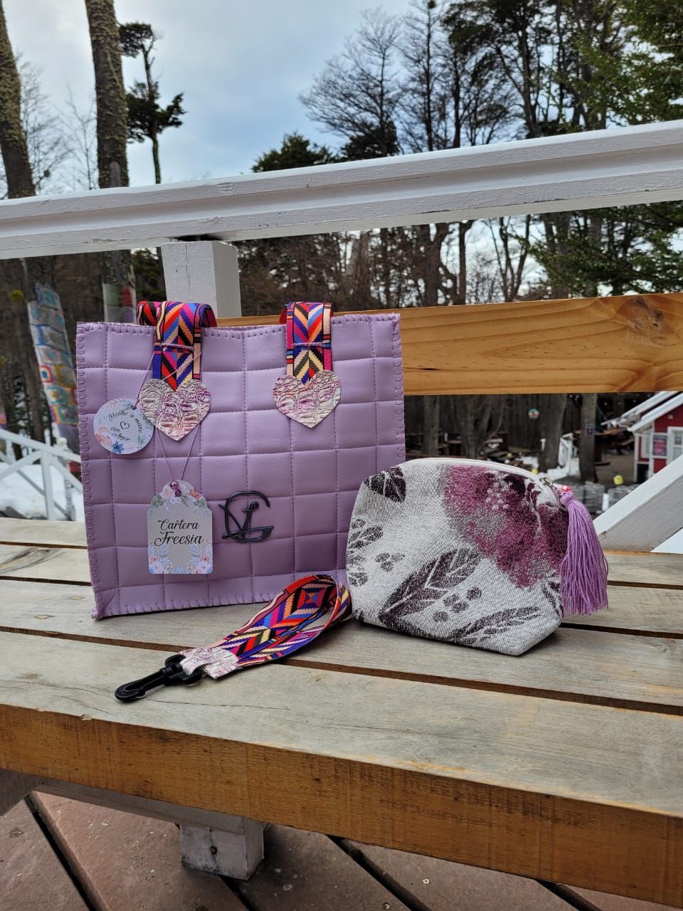 Dos bolsas de color morado están sobre un banco de madera.