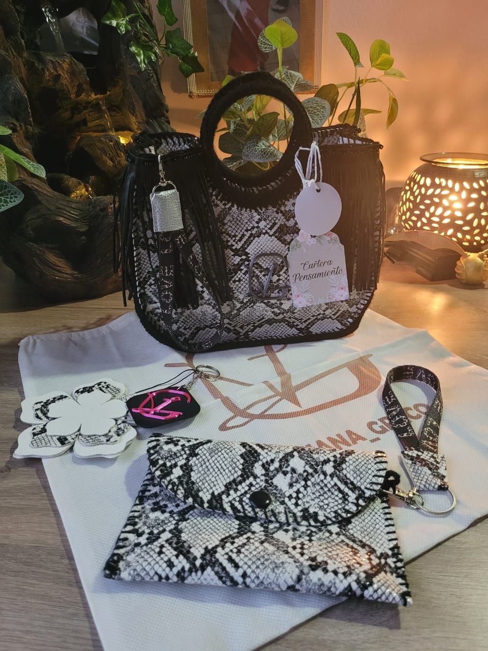 Un bolso blanco y negro está encima de una toalla blanca.