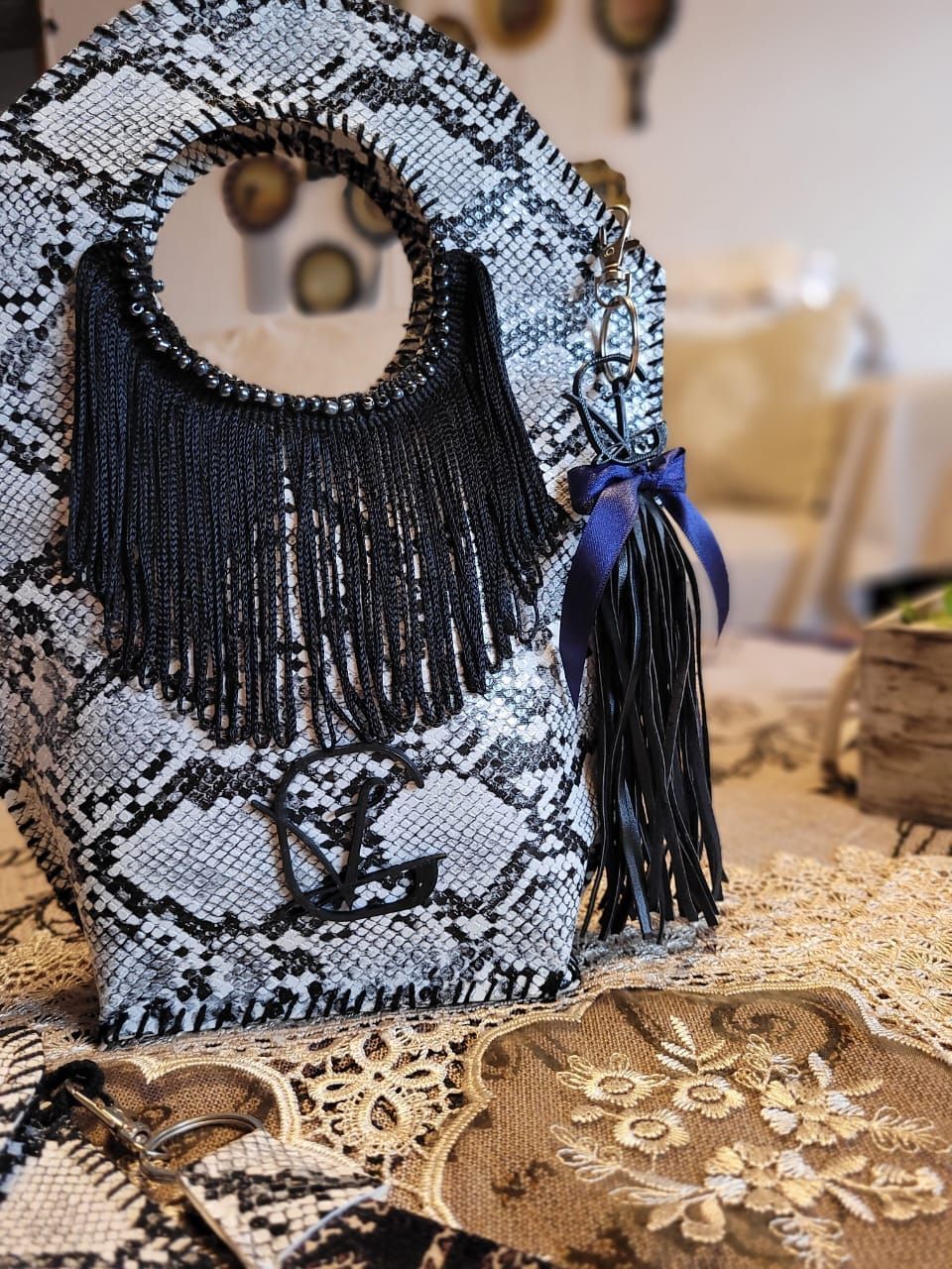 Un bolso blanco y negro con flecos reposa sobre una mesa.