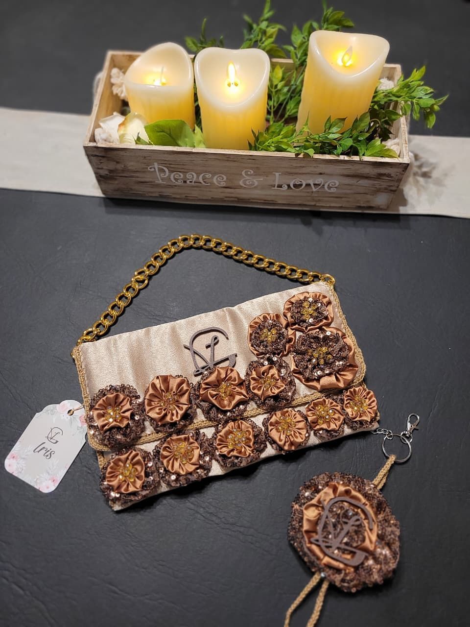 Un bolso reposa sobre una mesa junto a una caja de velas.