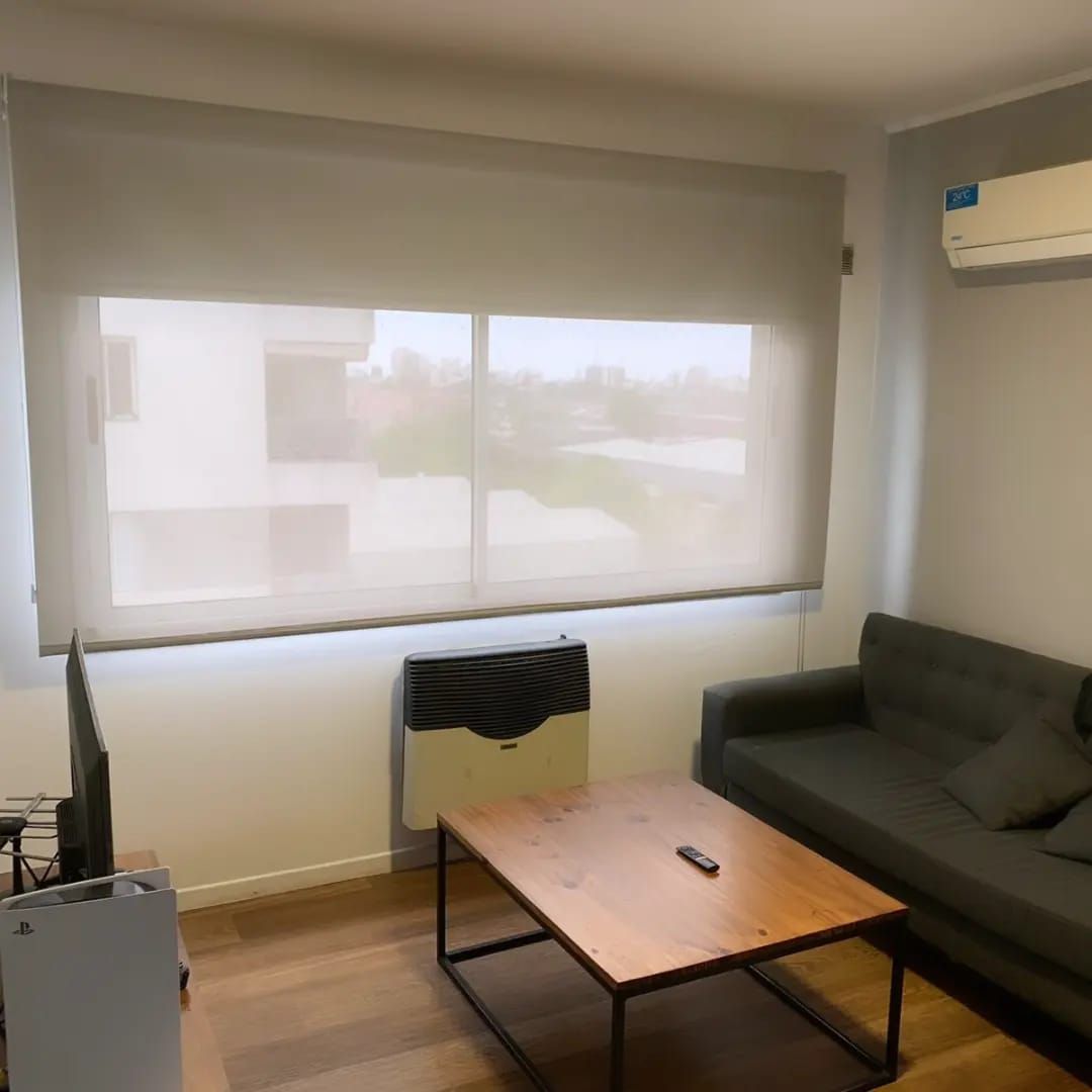 Un salón luminoso con un sofá gris