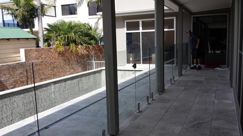 Man standing on a balcony with a mop in his hand — Balustrading in Unanderra NSW