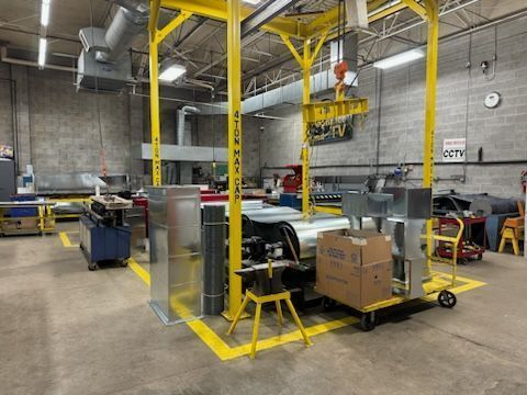 A factory with a lot of machinery and boxes on the floor.