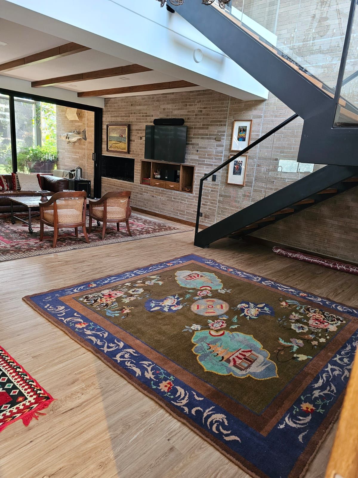 Una sala de estar con una alfombra en el piso y una escalera.