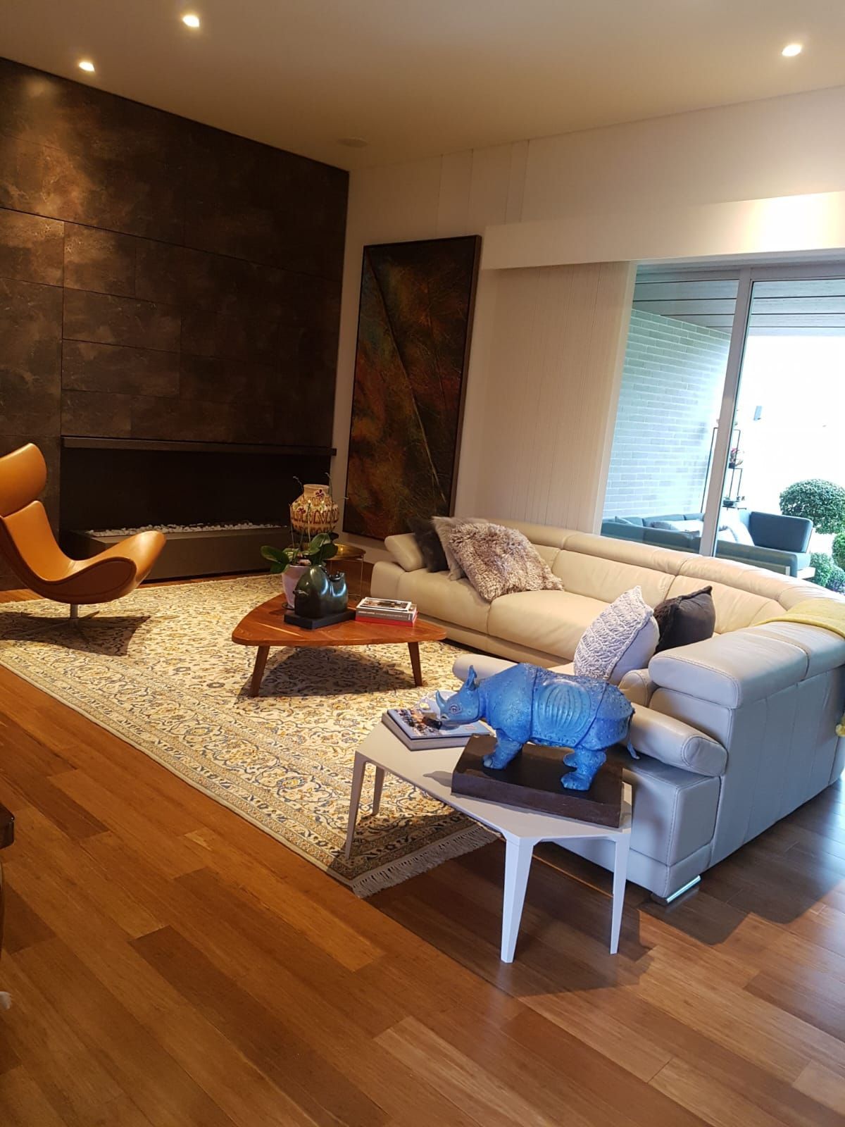 Una sala de estar con sofá, silla, mesa de café y una estatua de un elefante.