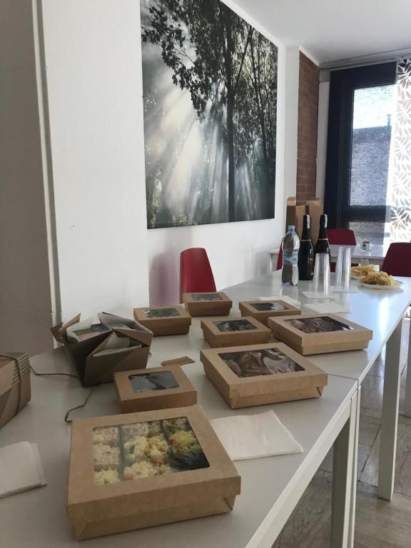 Un tavolo con sopra scatole di cibo e bottiglie di vino