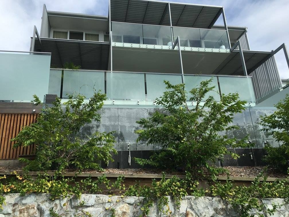 A large building with a lot of windows and trees in front of it — TSR Tinting & Frosting In Caloundra West, QLD